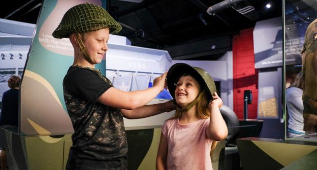 Children trying on helmets at D-Day Story